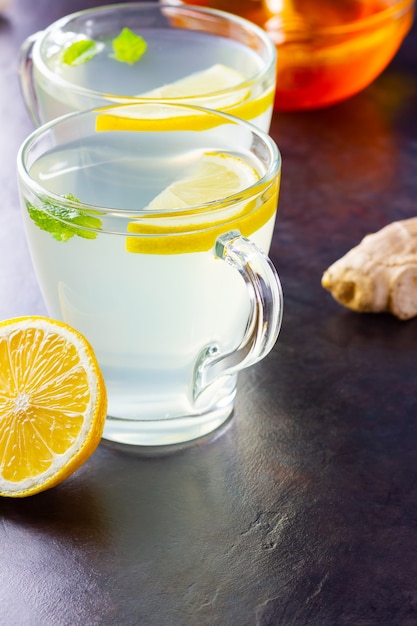 Ginger tea with lemon and mint on glass mugs