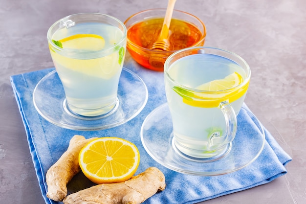 Ginger tea with lemon and mint on glass mugs