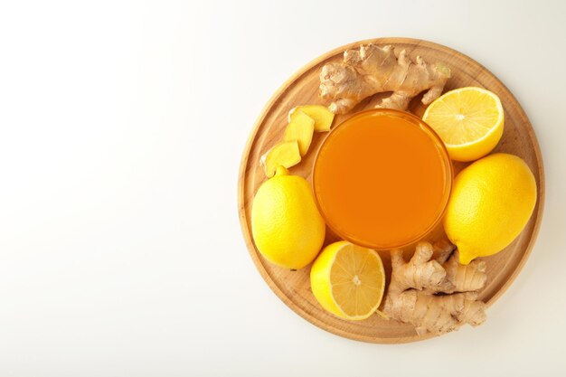 Ginger tea with lemon in a white cup on white background. Top view