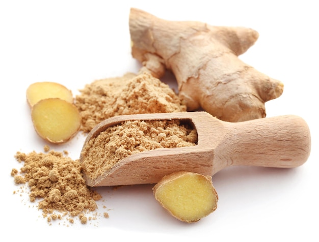 Ginger with dried powder over white background