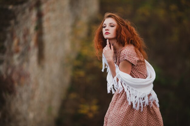 Ginger woman in shawl touching chin