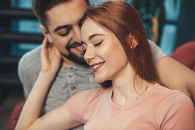 ginger woman with freckles is embracing her lover