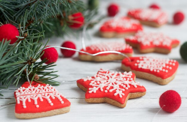 Gingerbread bells, stars, garland of felted beads and fir branches on a light 