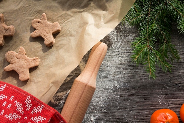 Gingerbread cakes in the form of men and houses are on a baking sheet new year decorations in the ki