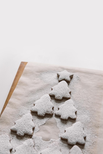 Gingerbread christmas tree sprinkled with powdered sugar on parchment