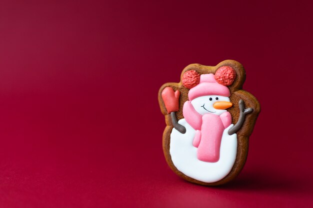 Gingerbread cookie of cute snowman on red