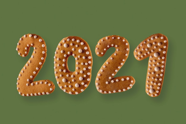 緑の中立的な背景の数字の形でジンジャーブレッドクッキー新年のコンセプト