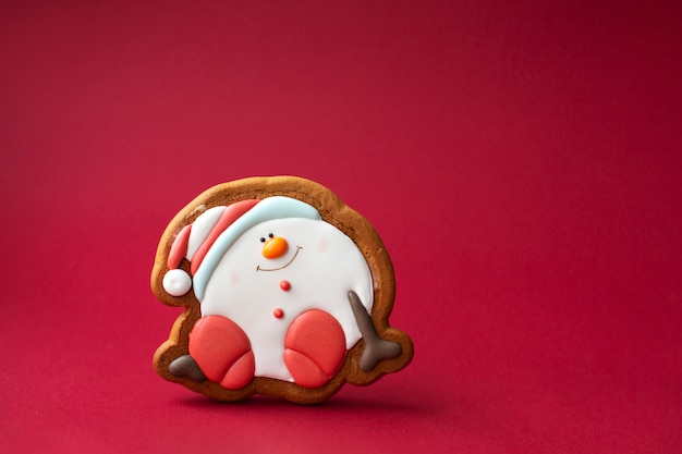 Gingerbread cookie of round snowman on red 