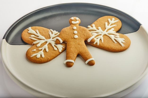 Gingerbread cookie in the shape of hearts and a man on a white and black plate