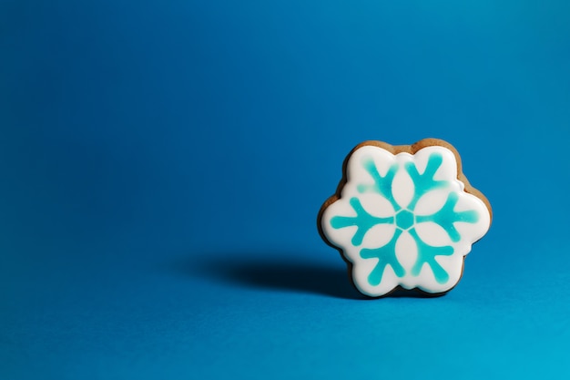 Gingerbread cookie of snowflake on blue background. 