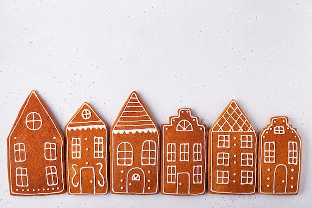 gingerbread cookies in the shape of houses on a white stone background