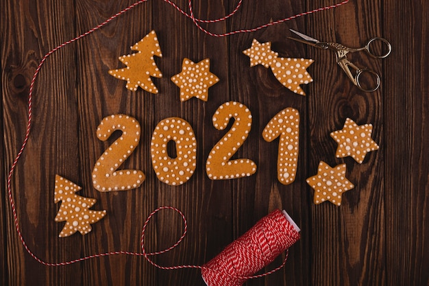 나무 테이블에 다른 크리스마스 쿠키와 함께 새해 2021 년 숫자 모양의 진저 브레드 쿠키