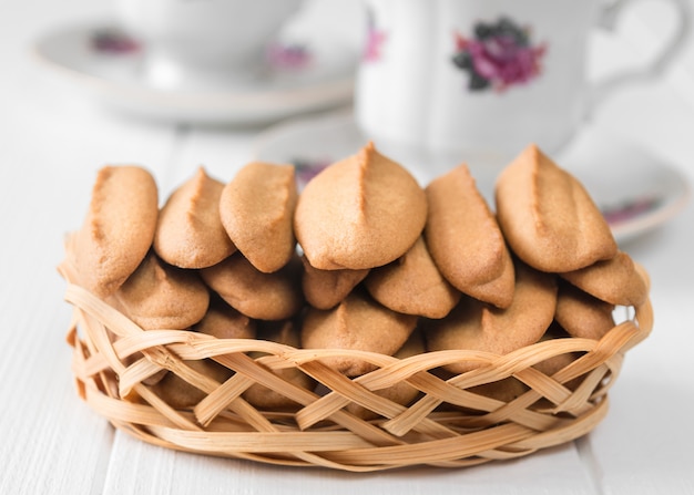 Biscotti di pan di zenzero con una tazza di caffè su una tavola di legno bianca.