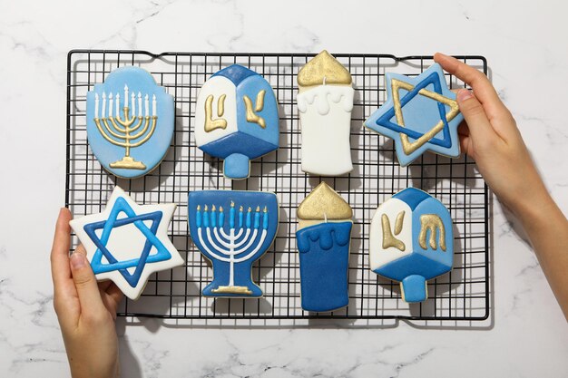 Foto biscotti di pan di zenzero con segni ebraici in mano su sfondo di marmo vista dall'alto