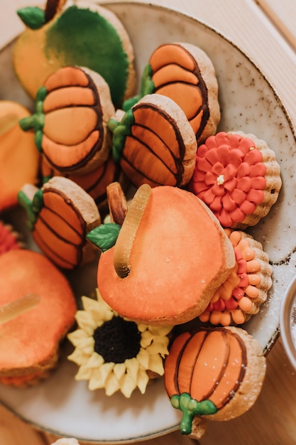 착색된 설탕으로 덮인 진저브레드는 쿠키 근접 촬영을 칠했습니다. 수제 케이크, 과자 및 과일이 나무 식탁에 있습니다. 고품질 사진