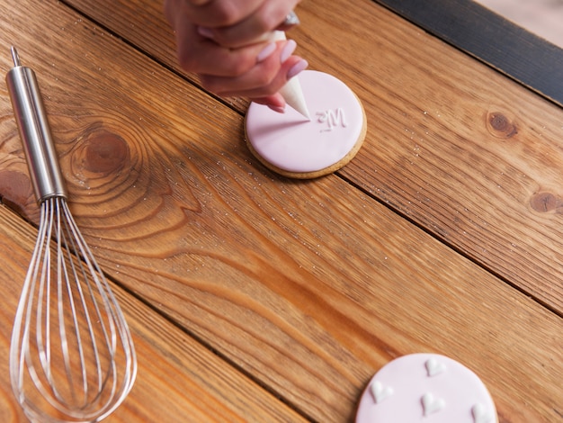 Gingerbread decorated on wooden table top view. Cooking process, colorful dessert, tasty food, bakery concept