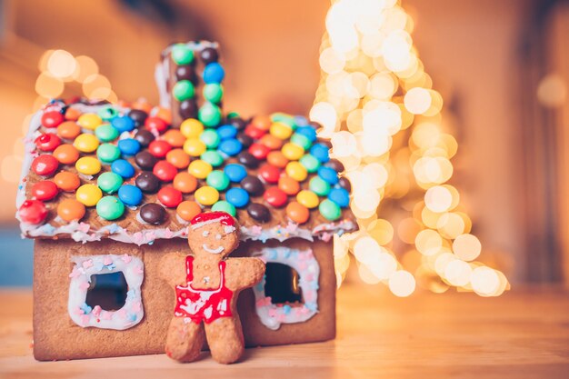 Gingerbread fairy house on a of bright Christmas tree with garland