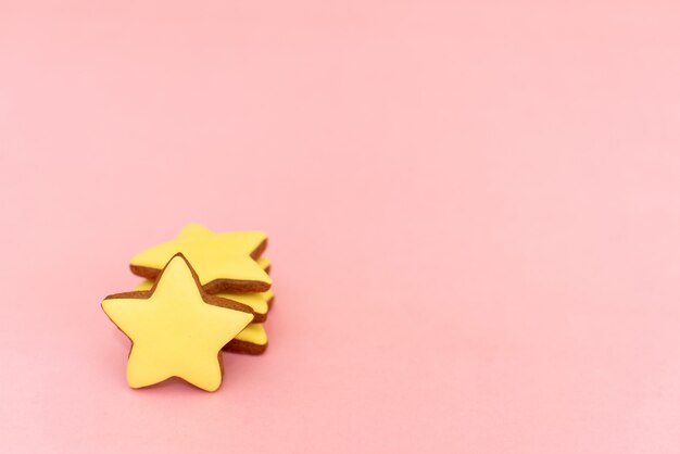 Gingerbread in the form of yellow stars on pink