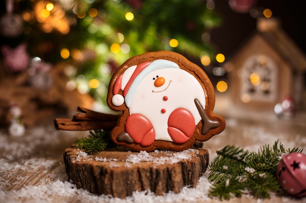 Gingerbread happy sitting Snowman or snowball in cozy warm decoration with garland lights