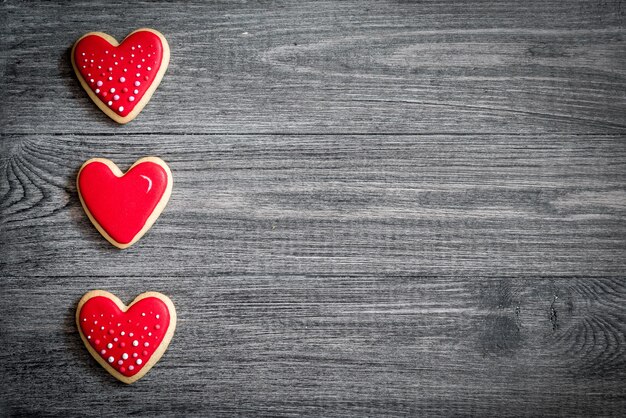 Gingerbread heart cookies on a rustic wooden table, flat lay