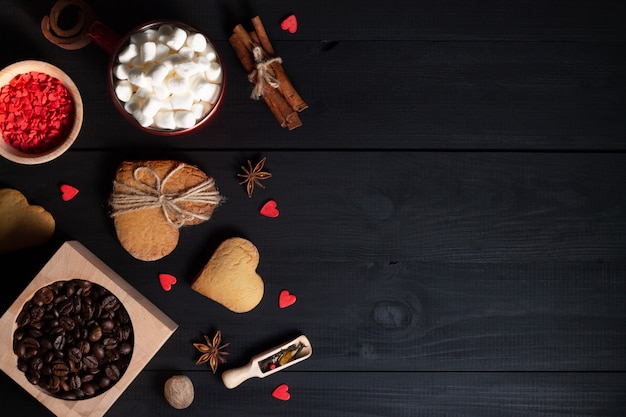 Пряники, печенье в форме сердца, специи, кофейные зерна и принадлежности для выпечки.