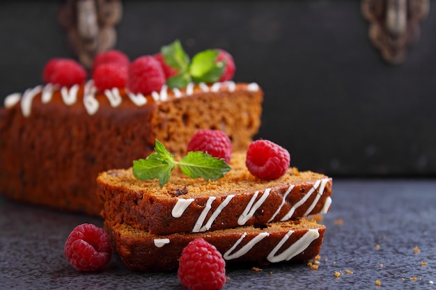 Gingerbread (honey-cake) with raisins decorated with icing, mint leaves and raspberries