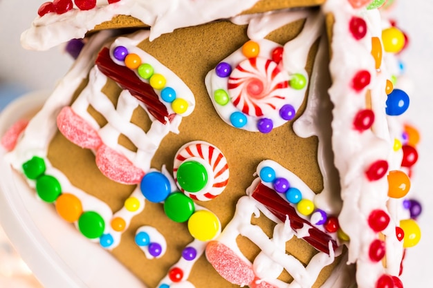 Gingerbread house decorated with white royal icing and bright candies.