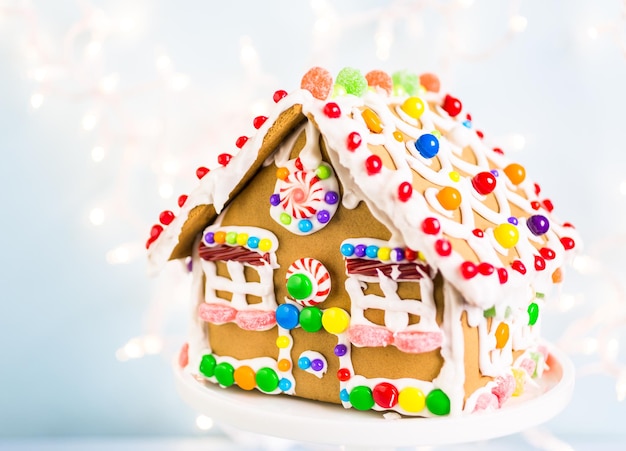 Gingerbread house decorated with white royal icing and bright candies.