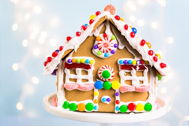 Gingerbread house decorated with white royal icing and bright candies.