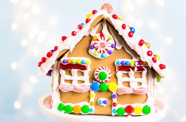 Gingerbread house decorated with white royal icing and bright candies.