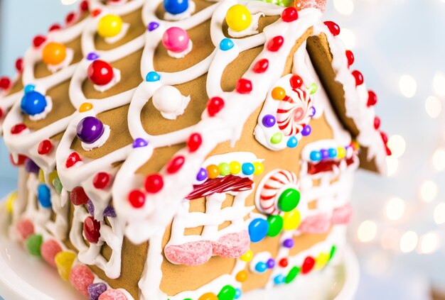 Gingerbread house decorated with white royal icing and bright candies.