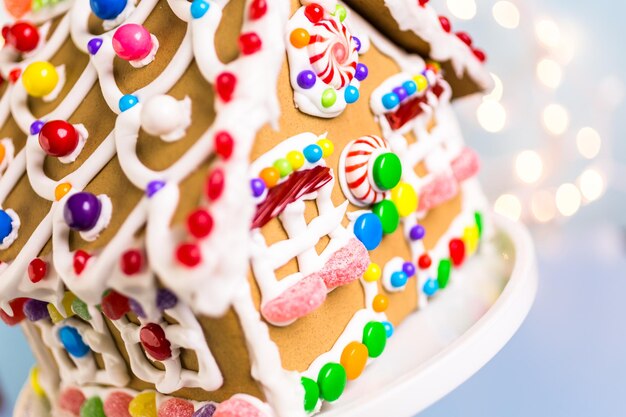 Gingerbread house decorated with white royal icing and bright candies.