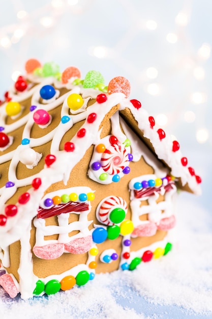 Gingerbread house decorated with white royal icing and bright candies.