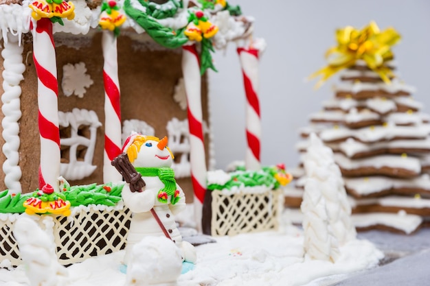 Gingerbread house, gingerbread Christmas tree and a sugar mastic snowman. Mockup for seasonal offers and holiday post card