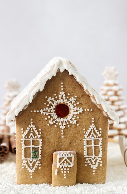 Photo gingerbread house and gingerbread tree on a light