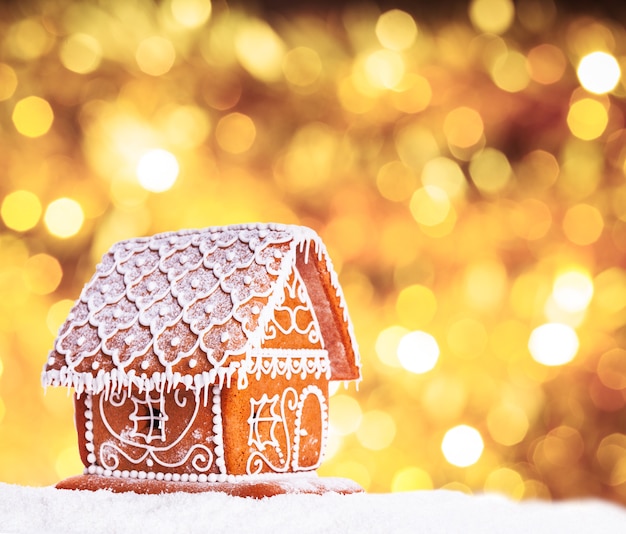 Gingerbread house on a snow over bokeh backgrond