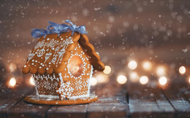 Gingerbread house on wooden background Symbol of Christmas and winter holidays