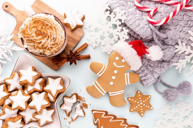 Gingerbread man cookies and Christmas decor on pastel background