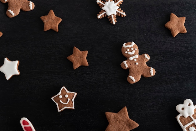 Gingerbread man and stars close up on black background. Traditional pastries.