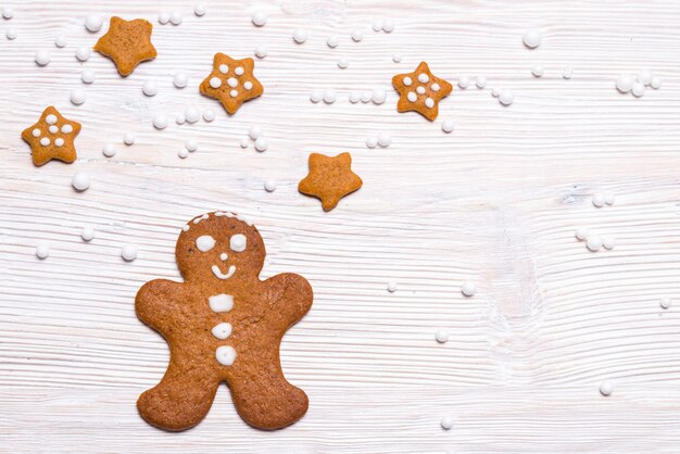 Gingerbread man and stars on wooden table