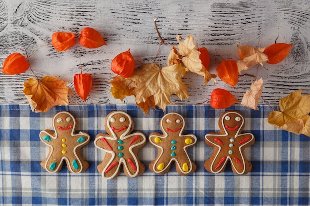 Gingerbread men lined up on a natural wood table 