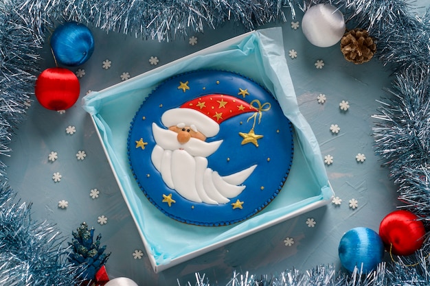 Gingerbread Santa Claus on a blue table, gifts christmas or Noel holiday, horizontal orientation