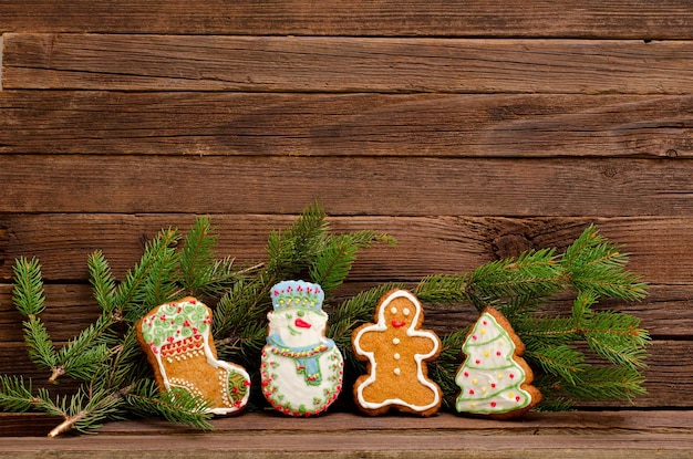 Gingerbread sock snowman man firtree spruce branch on a background of a wooden wall with space for text