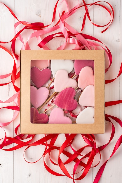 Gingerbread on a stick in the shape of hearts in a gift box a light table. Valentine's Day.