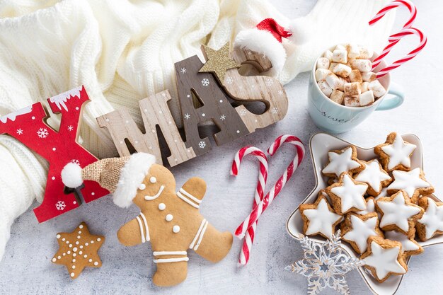 Gingerbread with mug of hot chocolate and christmas candy cane.