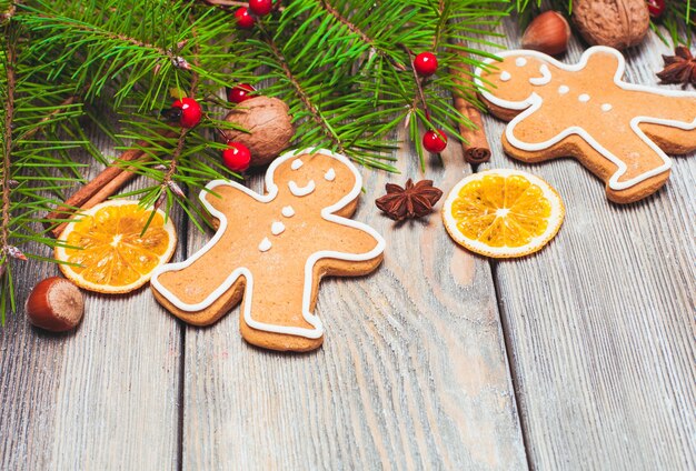 Gingerbreads and fir tree branches on the wooden table. Christmas decor