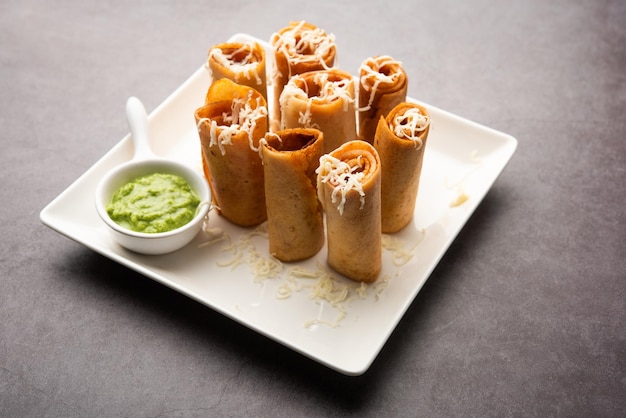 Foto gini of jini dosa is een streetfood-variëteit in mumbai-stijl geserveerd in een bord met groene chutney