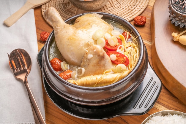 Куриный суп с женьшенем или традиционная корейская еда Samgyetang из курицы, фаршированной рисом