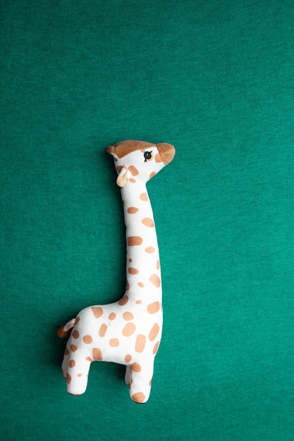 Giraffe toy on a green background children's soft toy