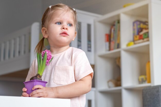 Girl 23 years old in a room with a potted flower in her hands Looking away planting plants the concept of caring for nature